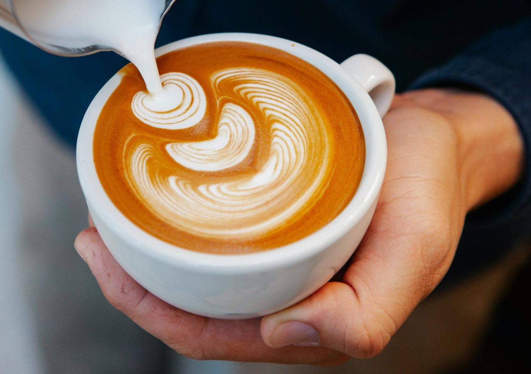 Persona sirviendo taza de café